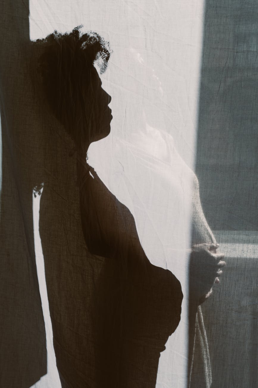 shadow of a woman holding her baby bump