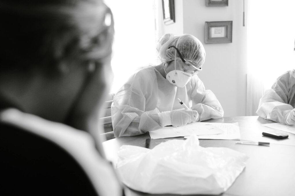 healthcare workers in protective gear writing documents