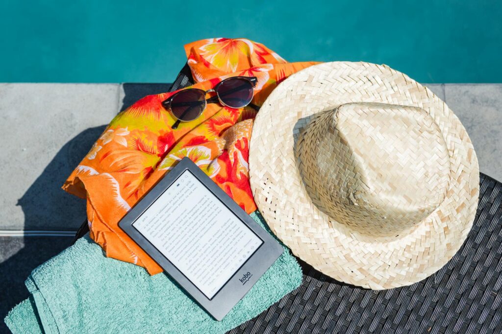 black amazon kindle tablet near brown drawstring sun hat