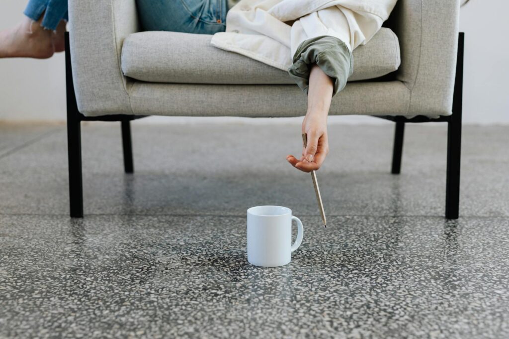 person lying on a sofa holding a pencil