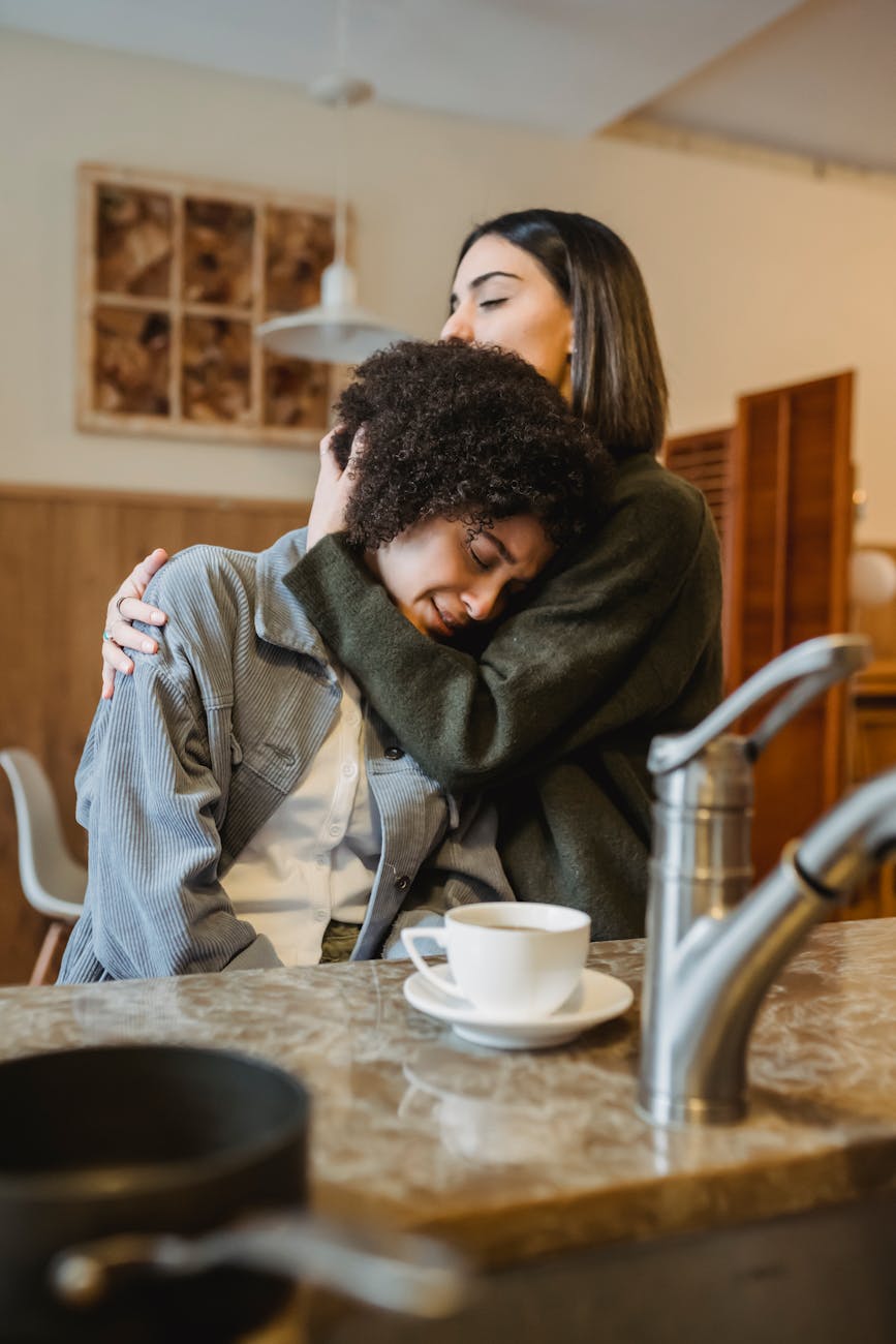caring woman embracing and comforting black friend