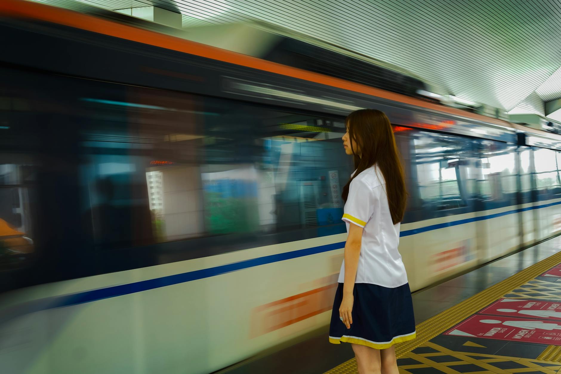 young woman waiting for train at station